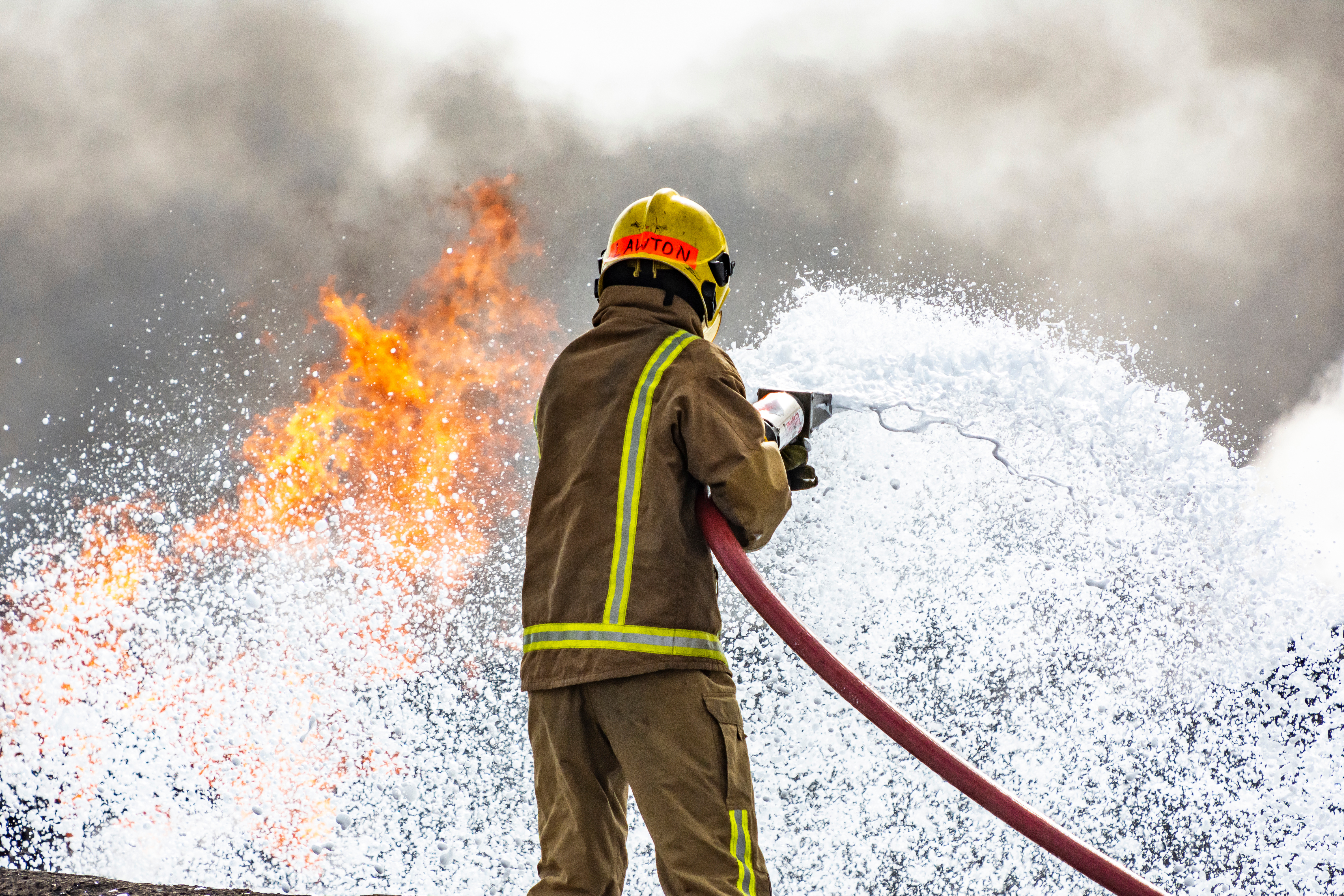 Firefighter using Aqueous Film Forming Foam (AFFF) to fight a fire, which usually contains PFAS