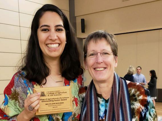 Mely Bohlman accepts an award with faculty advisor Dr. Joan Curry